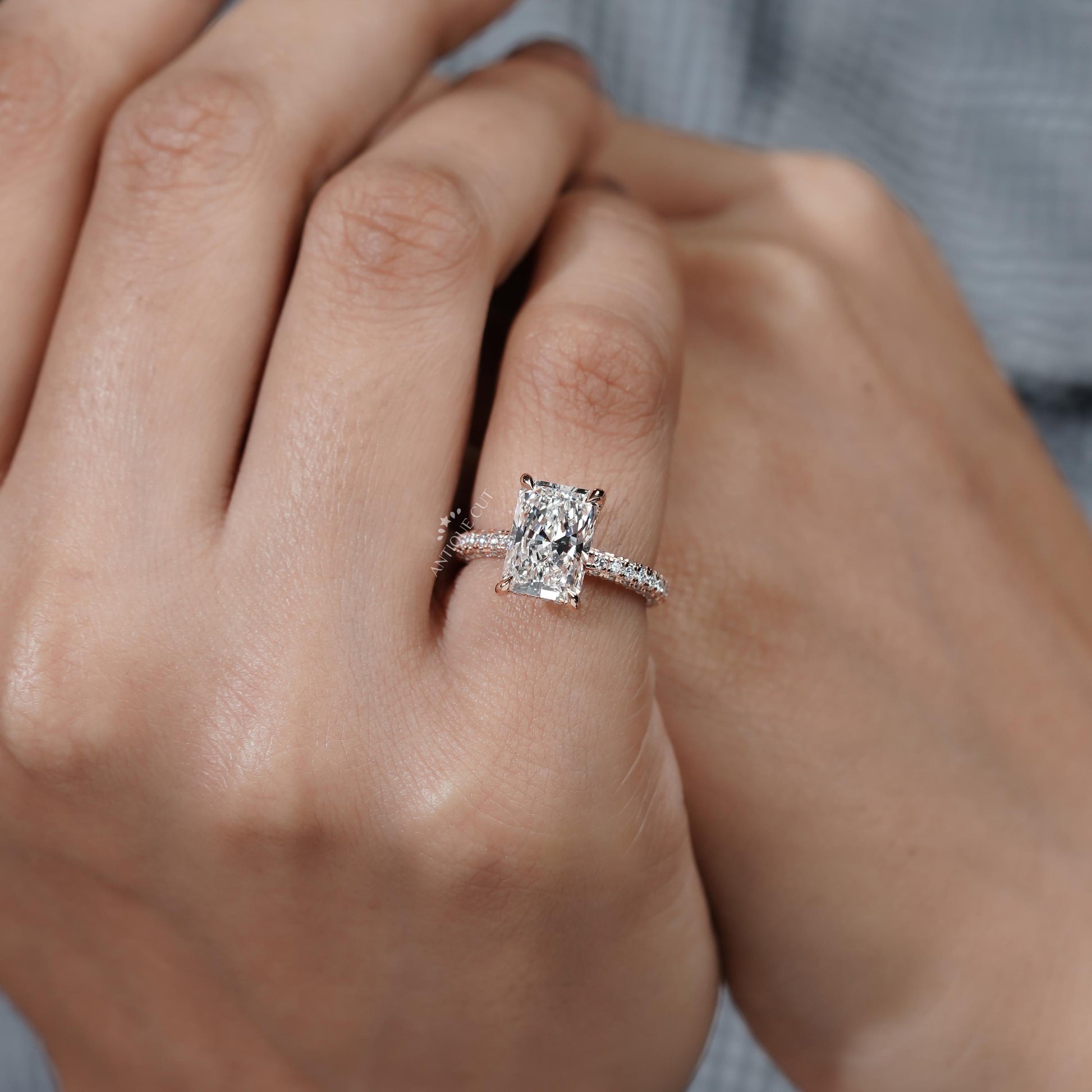 Close-up of a hand wearing a diamond ring with a blurred background

