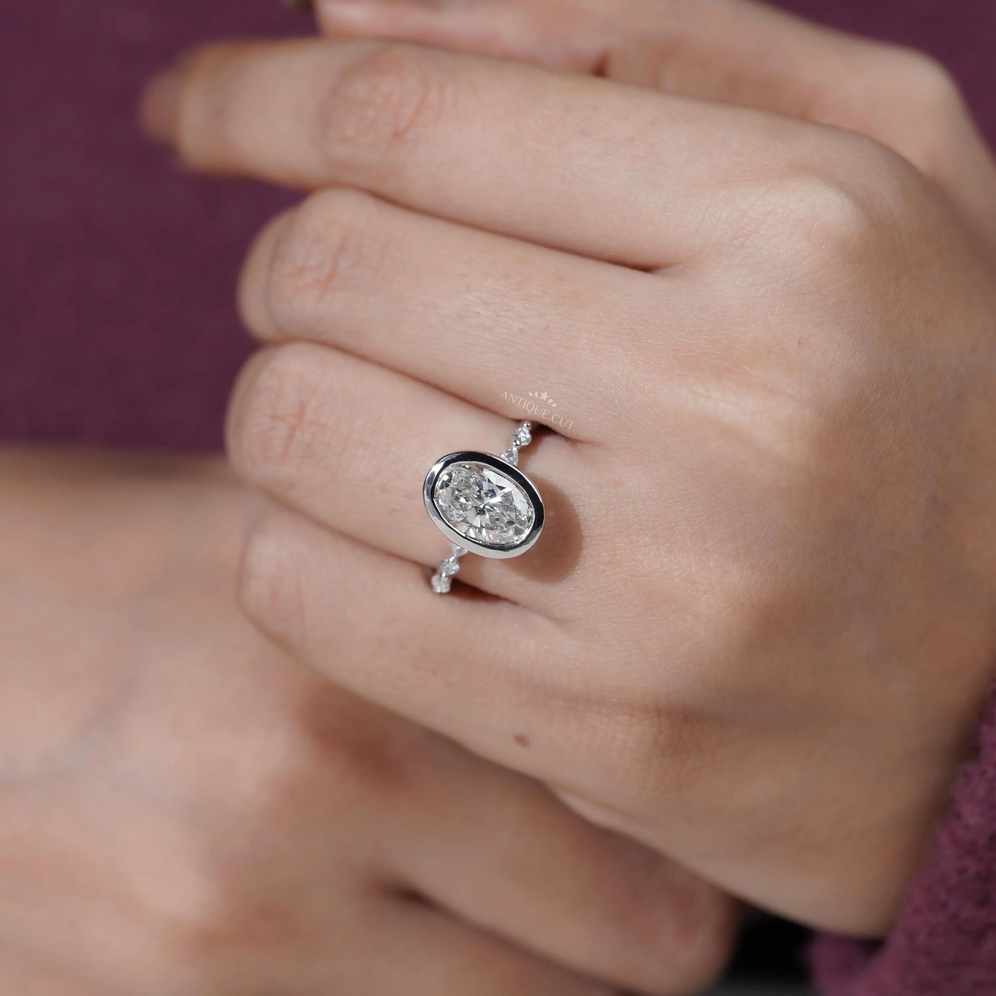 Close-up of a hand wearing a diamond ring with a blurred background