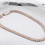 Rose gold chain necklace on a white surface