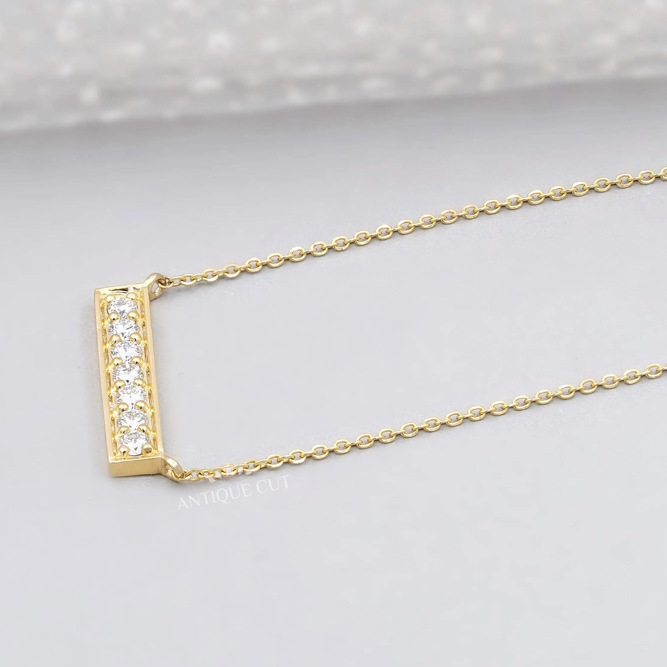 This necklace features a horizontal bar with sparkling diamonds.