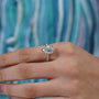 Diamond ring with a pear-shaped center stone on a soft blue background


