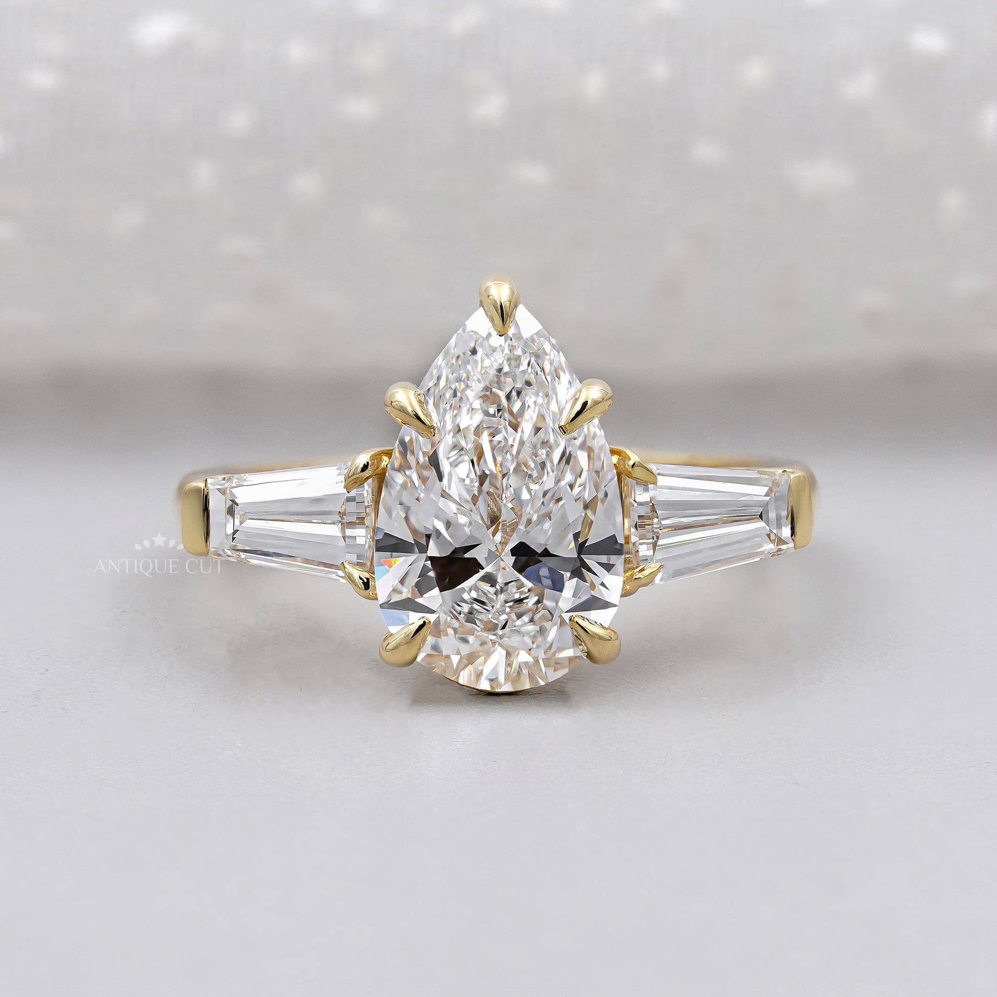 Three stone pear engagement ring in yellow gold