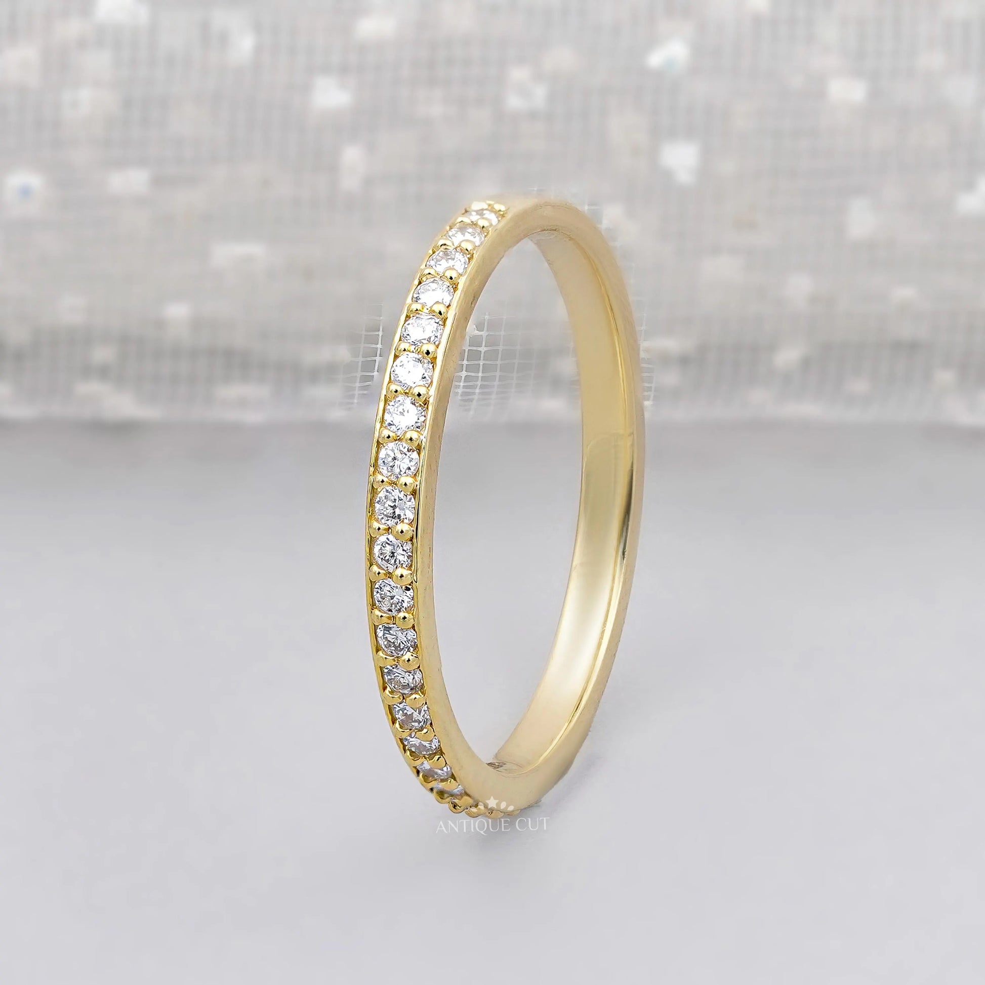 Gold ring with diamonds on a light gray background