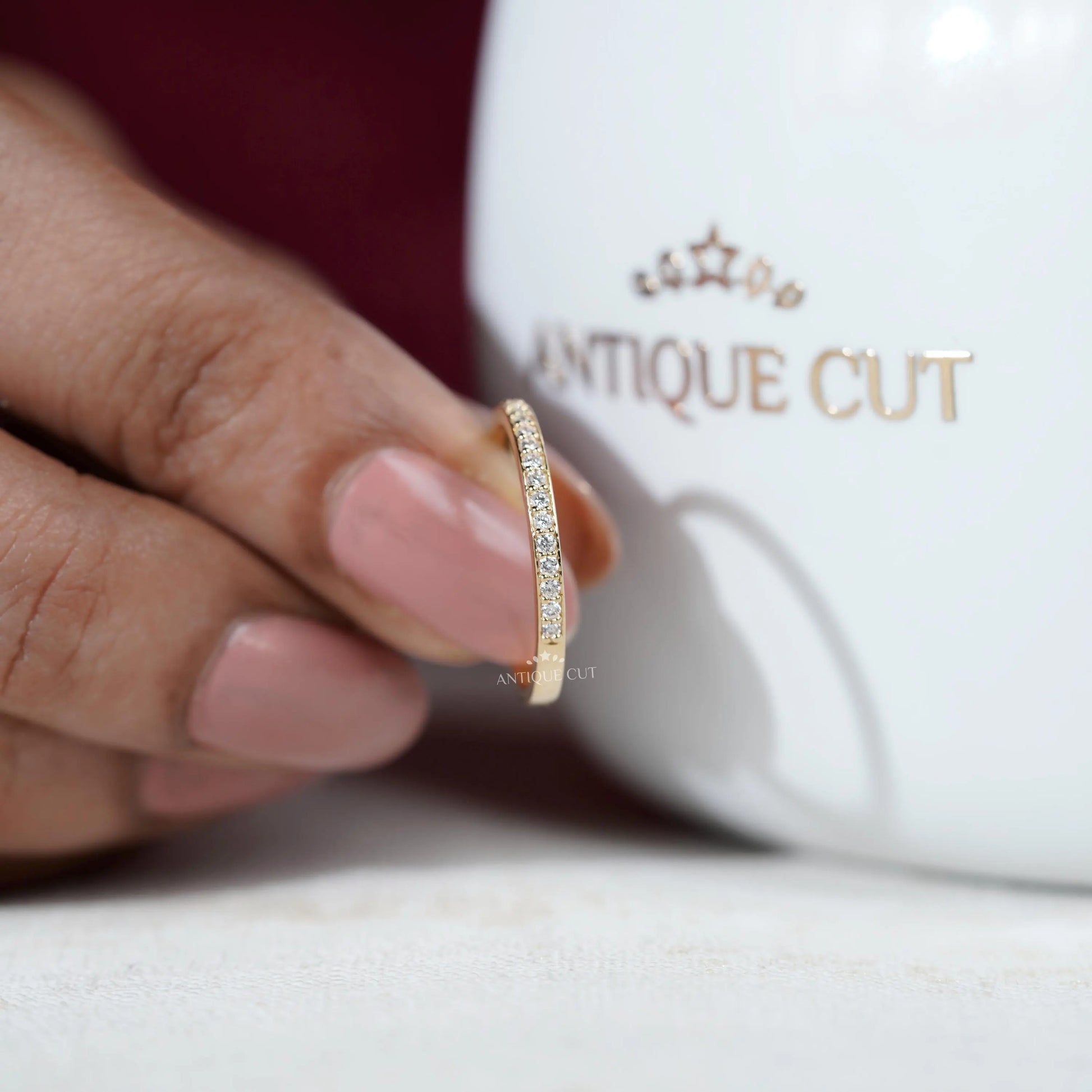 Gold ring with diamonds on a light gray background