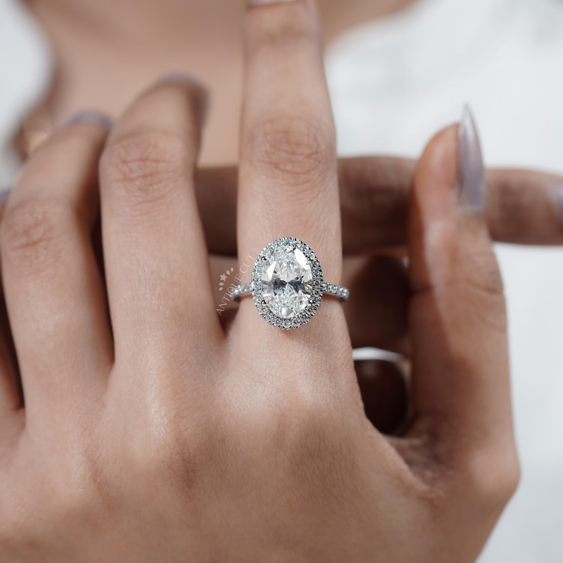 Diamond ring on a hand with a plain background

