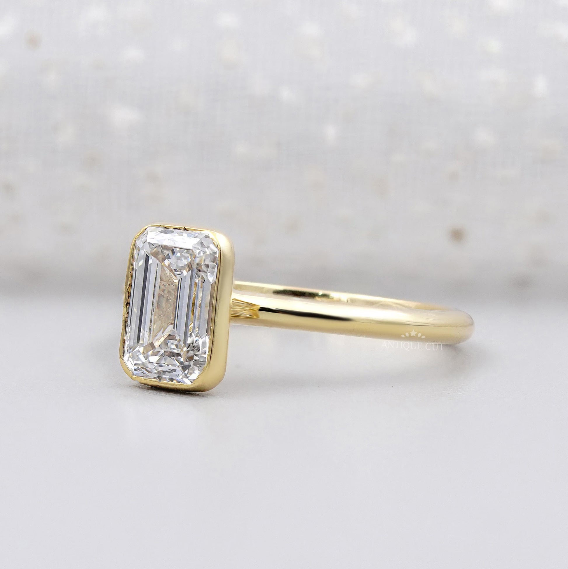 Bezel set emerald solitaire engagement ring