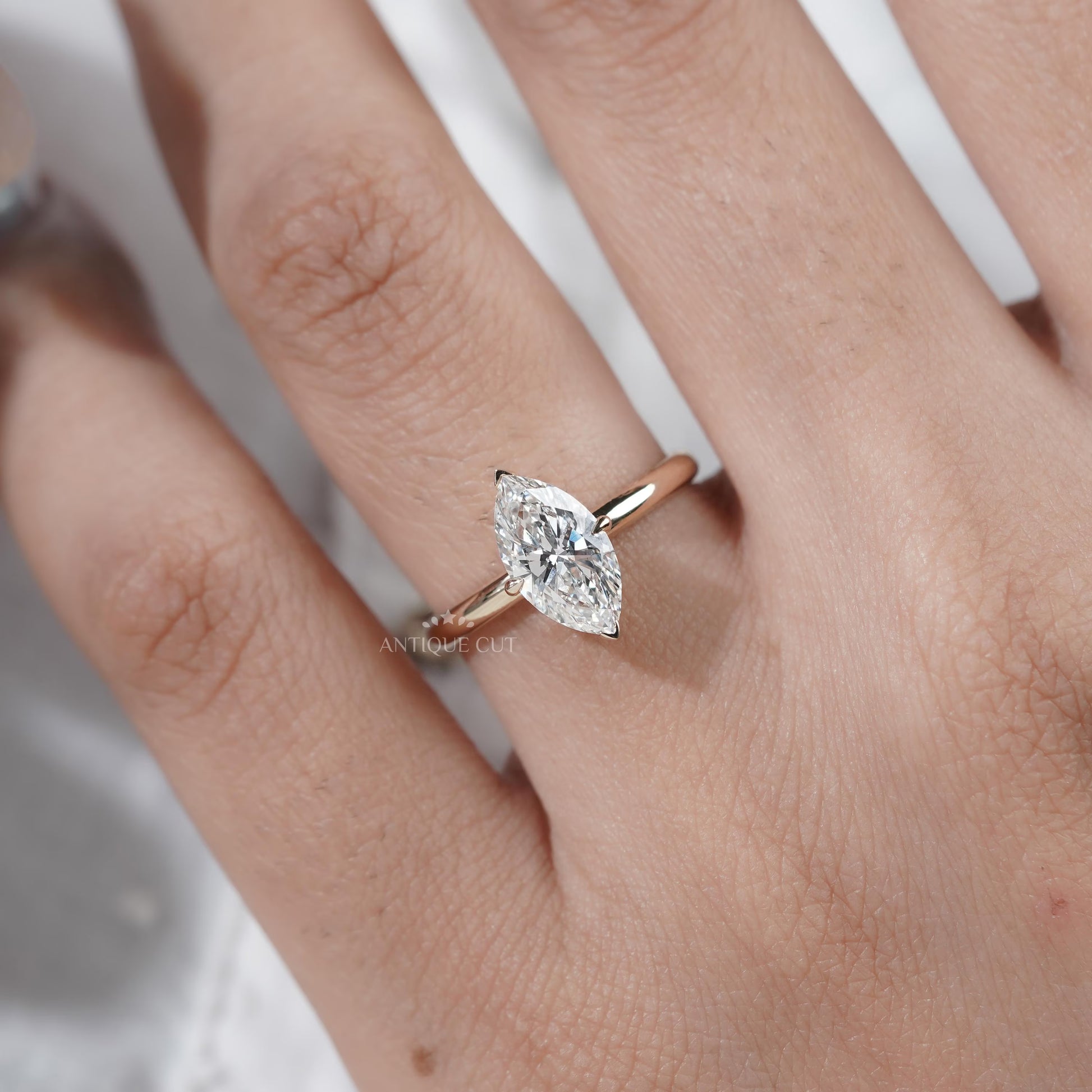 Close-up of a hand wearing a diamond ring on a white background

