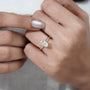 Close-up of a hand wearing a diamond ring on a white background

