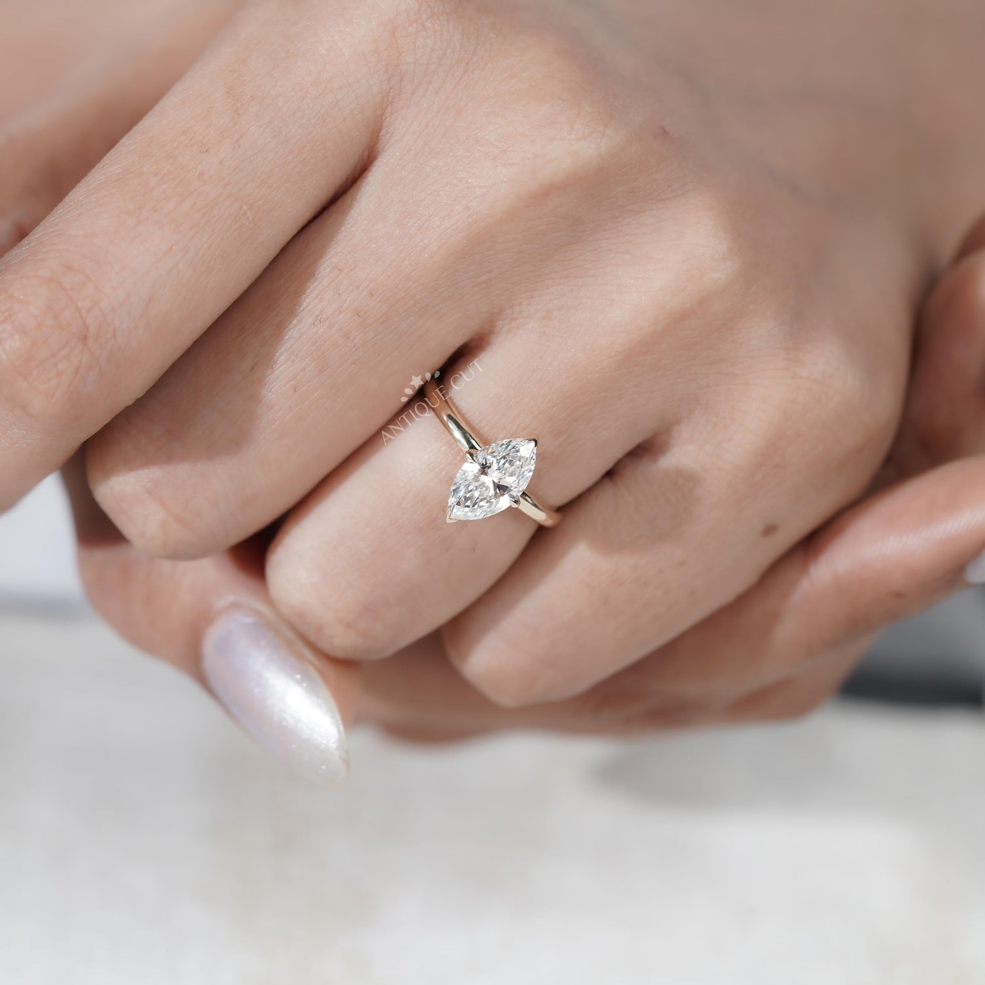 Close-up of a hand wearing a diamond ring on a white background

