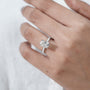 Silver ring with a diamond on a hand against a white background

