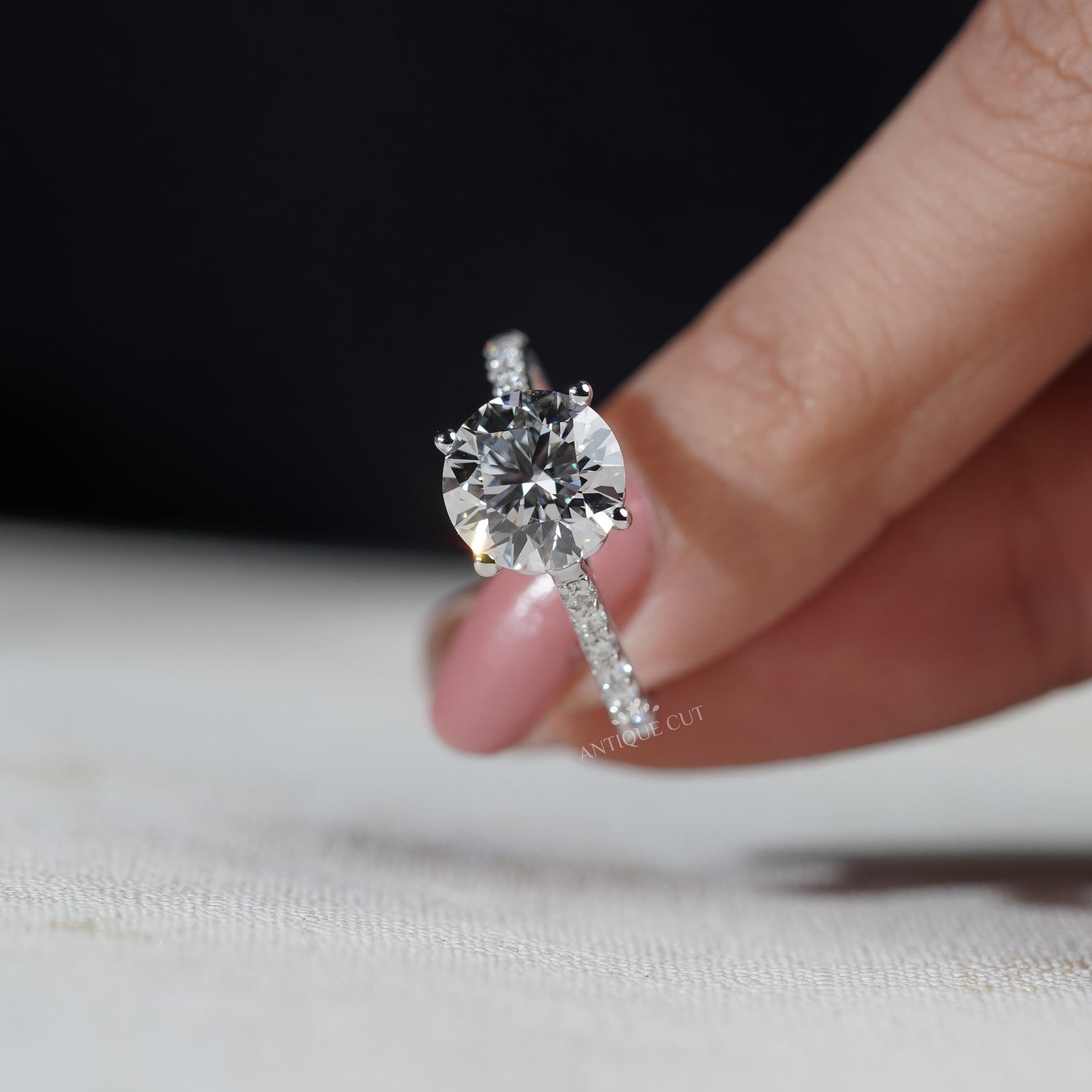 Close-up of a hand wearing a diamond ring with a blurred background