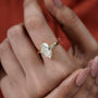 Gold ring with a large diamond on a hand against a red background