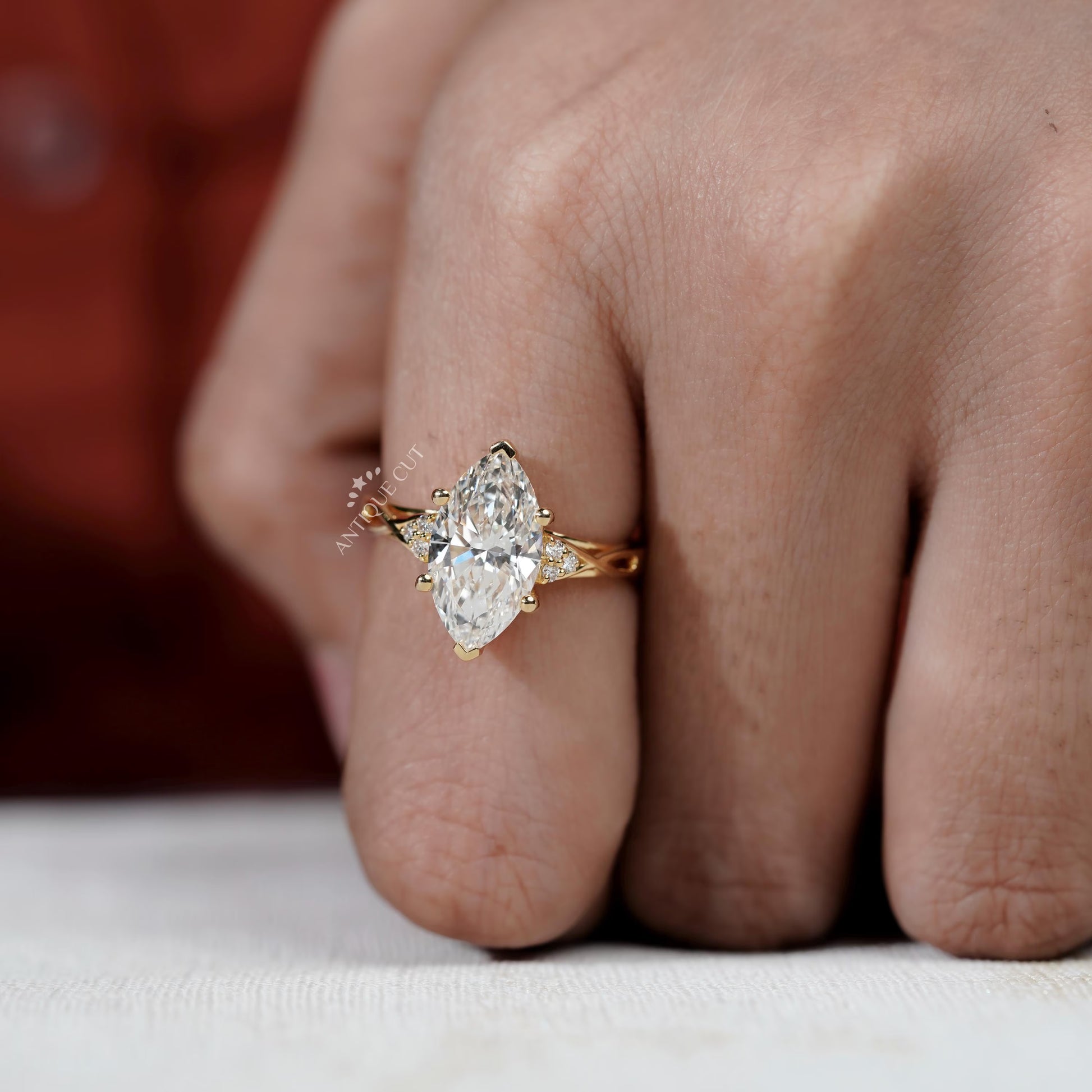Gold ring with a pear-shaped diamond on a finger

