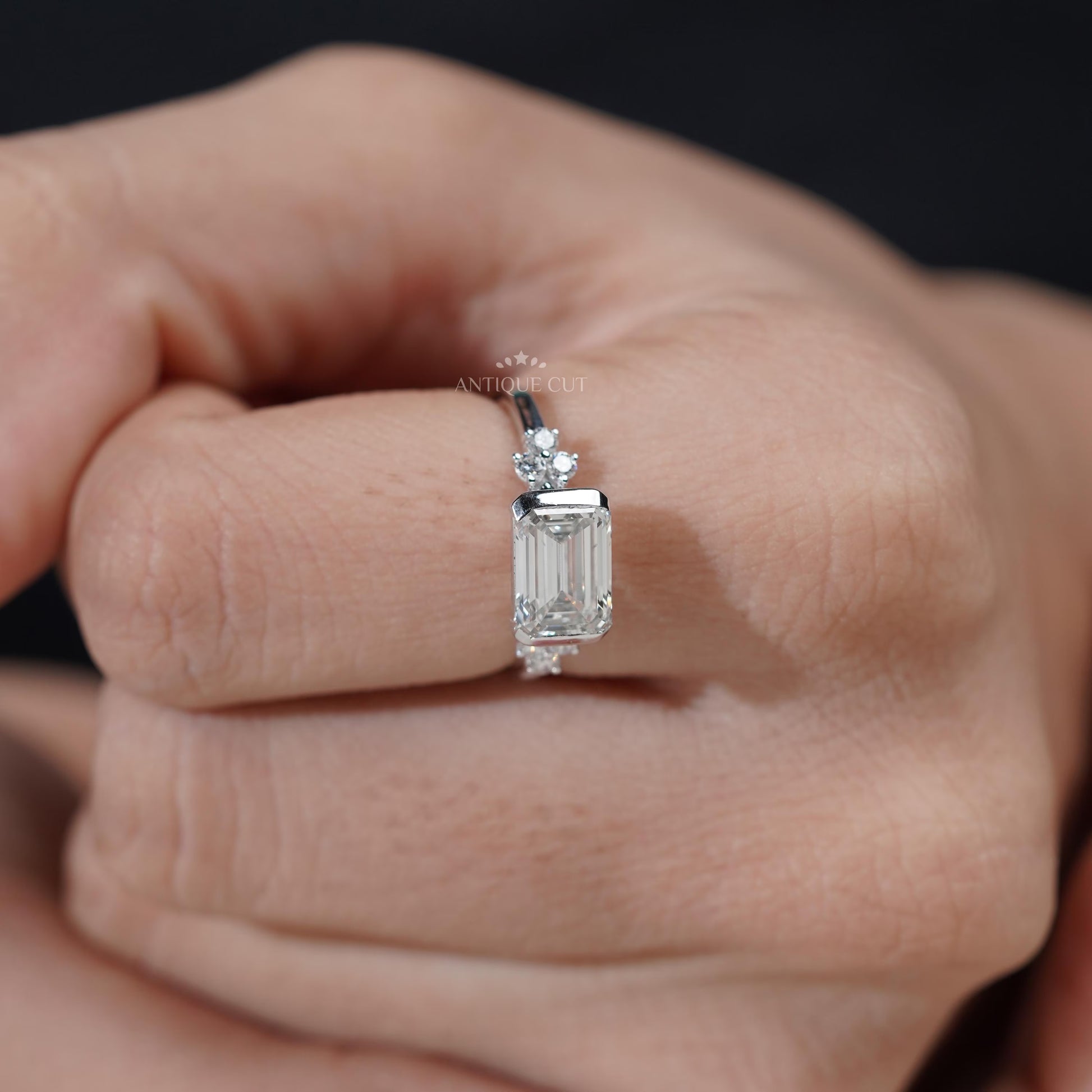 East west emerald cut ring with bezel set lab grown diamond
