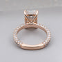 Rose gold ring with diamond accents on a light gray background

