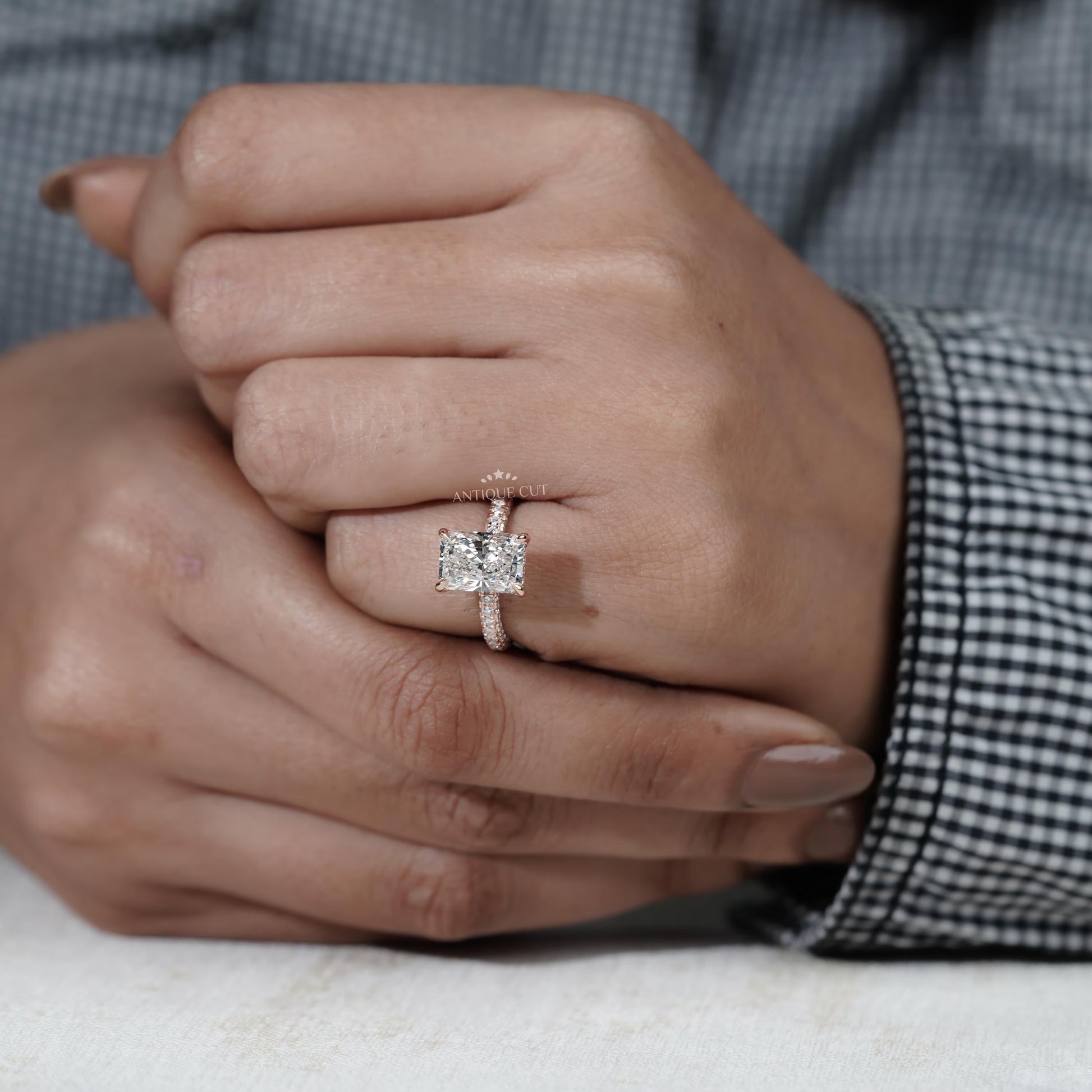 Close-up of a hand wearing a diamond ring with a blurred background

