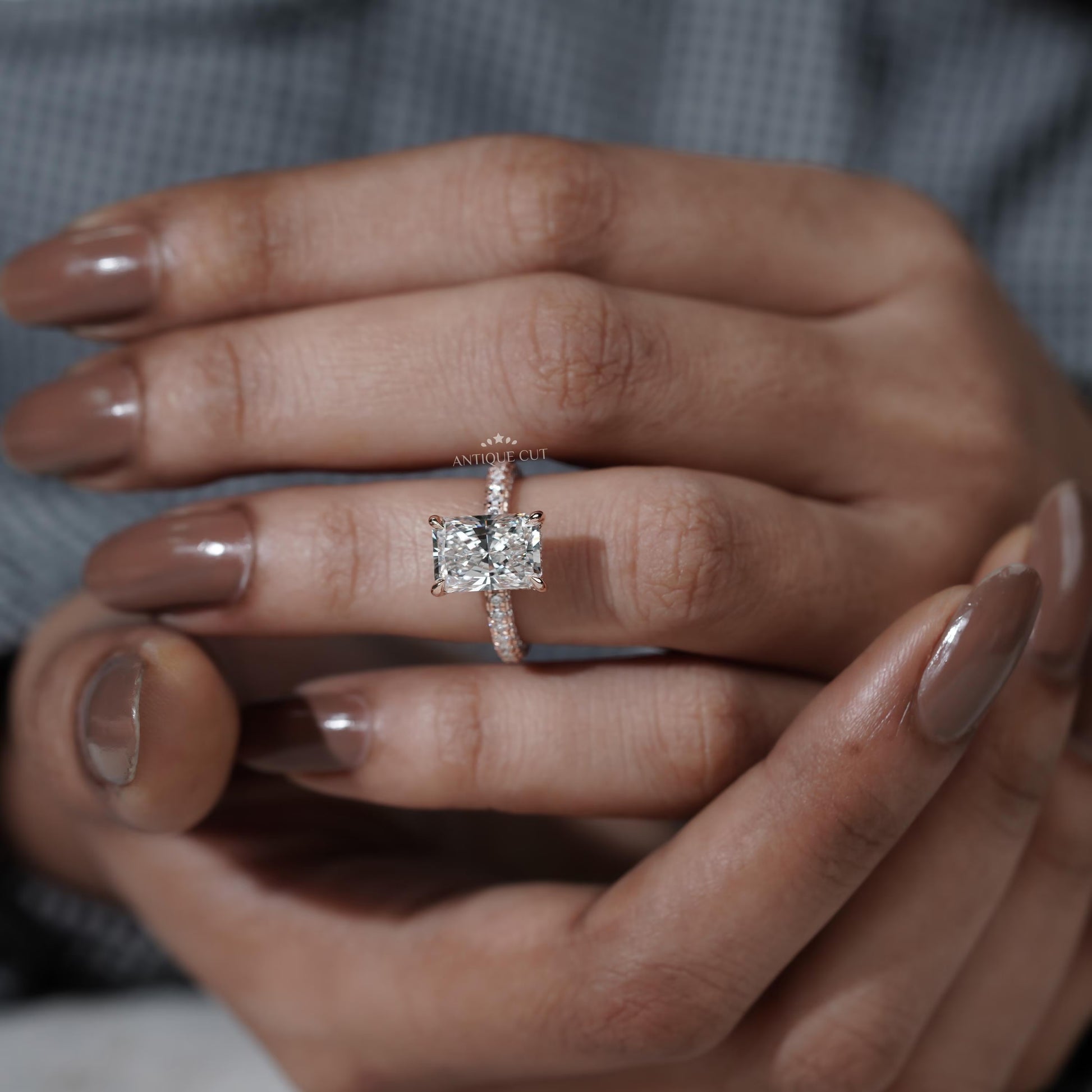Close-up of a hand wearing a diamond ring with a blurred background

