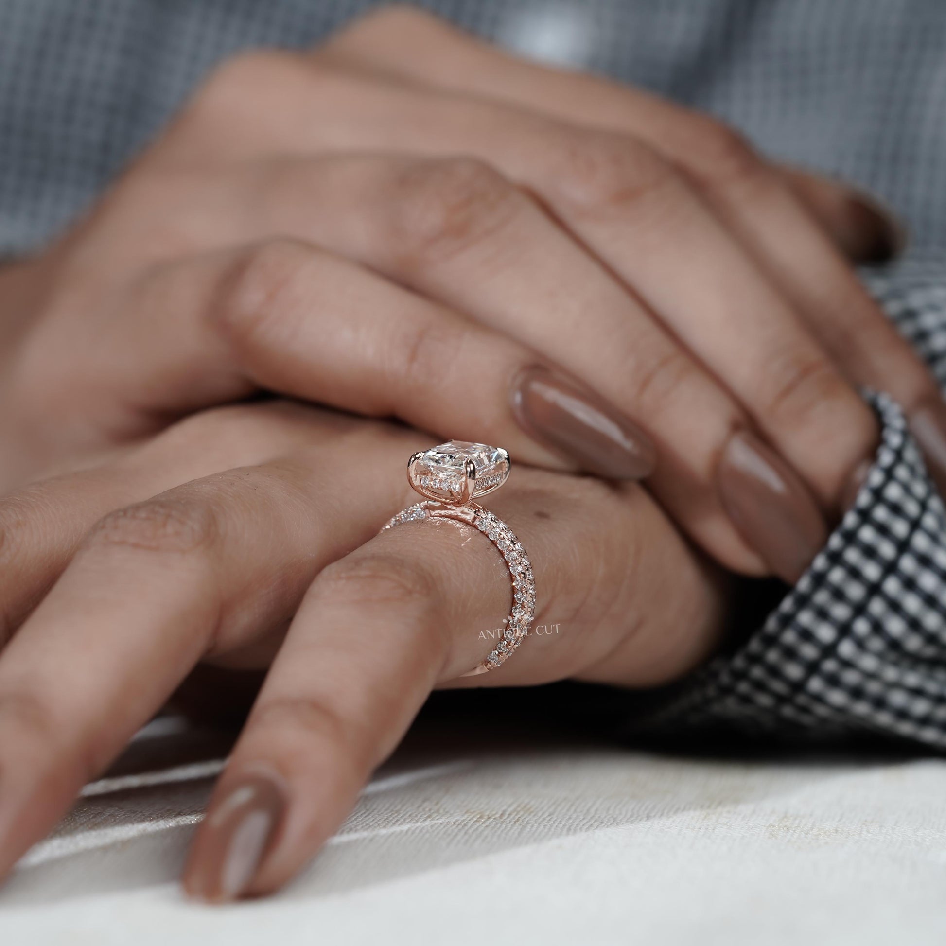 Close-up of a hand wearing a diamond ring with a blurred background

