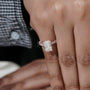 Close-up of a hand wearing a diamond ring with a blurred background

