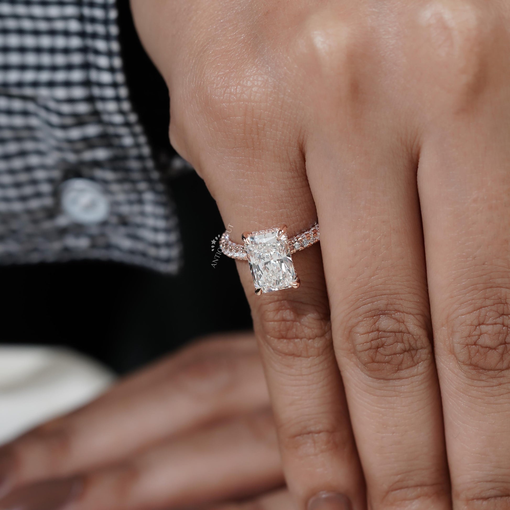 Close-up of a hand wearing a diamond ring with a blurred background

