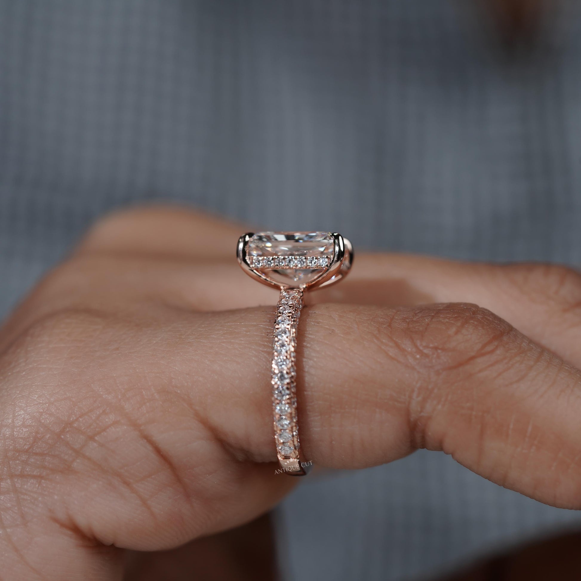 Close-up of a hand wearing a diamond ring with a blurred background

