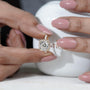 Gold ring with a diamond held by a hand against an 'Antique Cut' branded box.