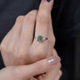 Timeless emerald cut green diamond ring with side stones