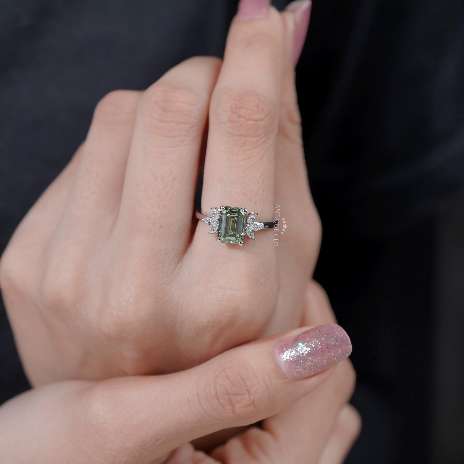 Timeless emerald cut green diamond ring with side stones