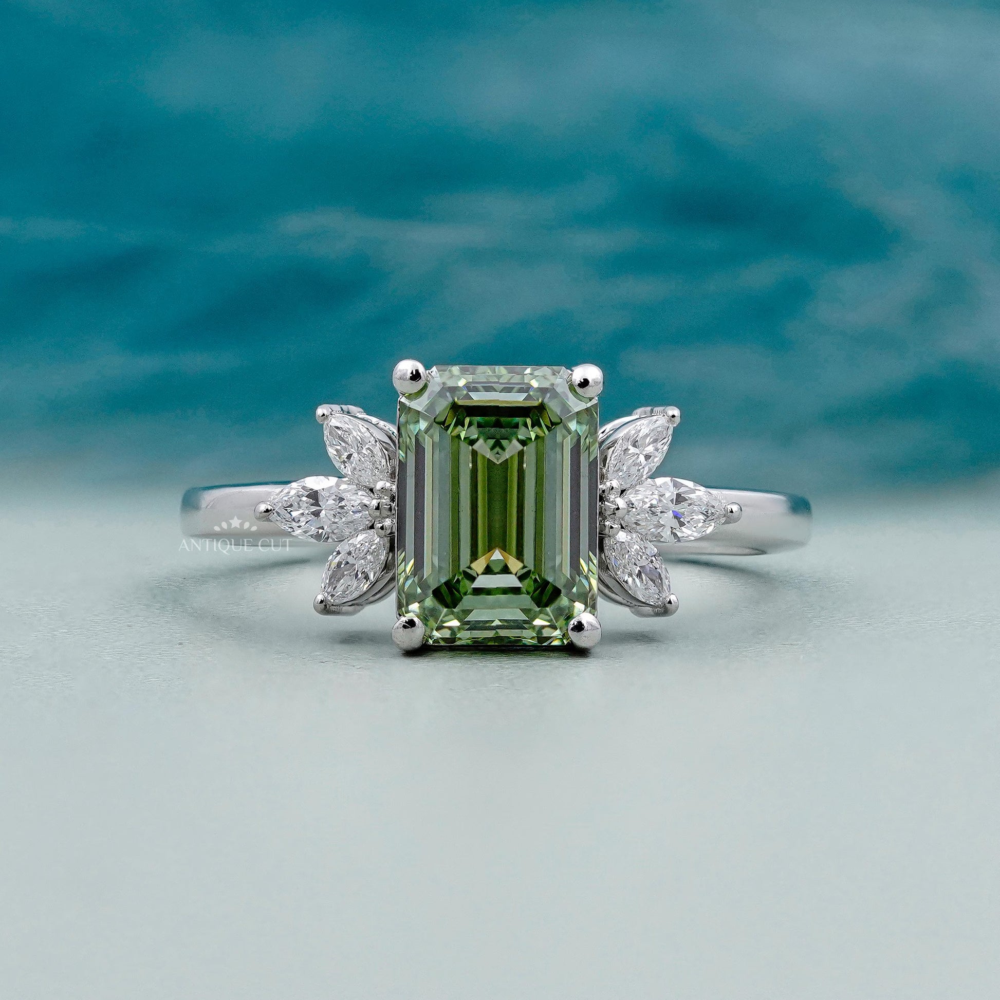 Emerald cut light green engagement ring with side stones