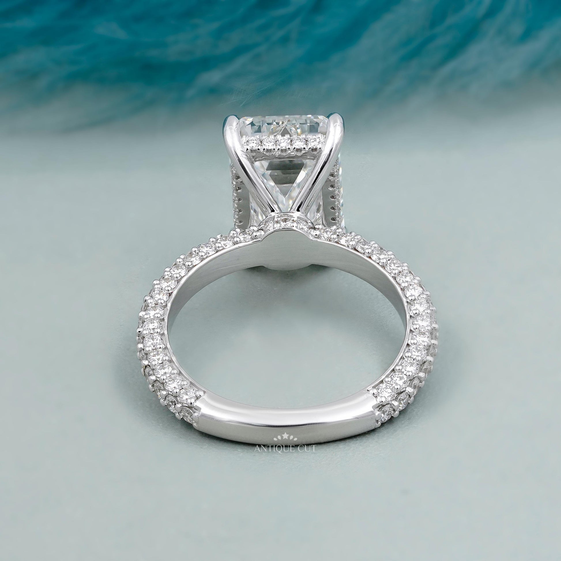 Emerald cut engagement ring with round side stones