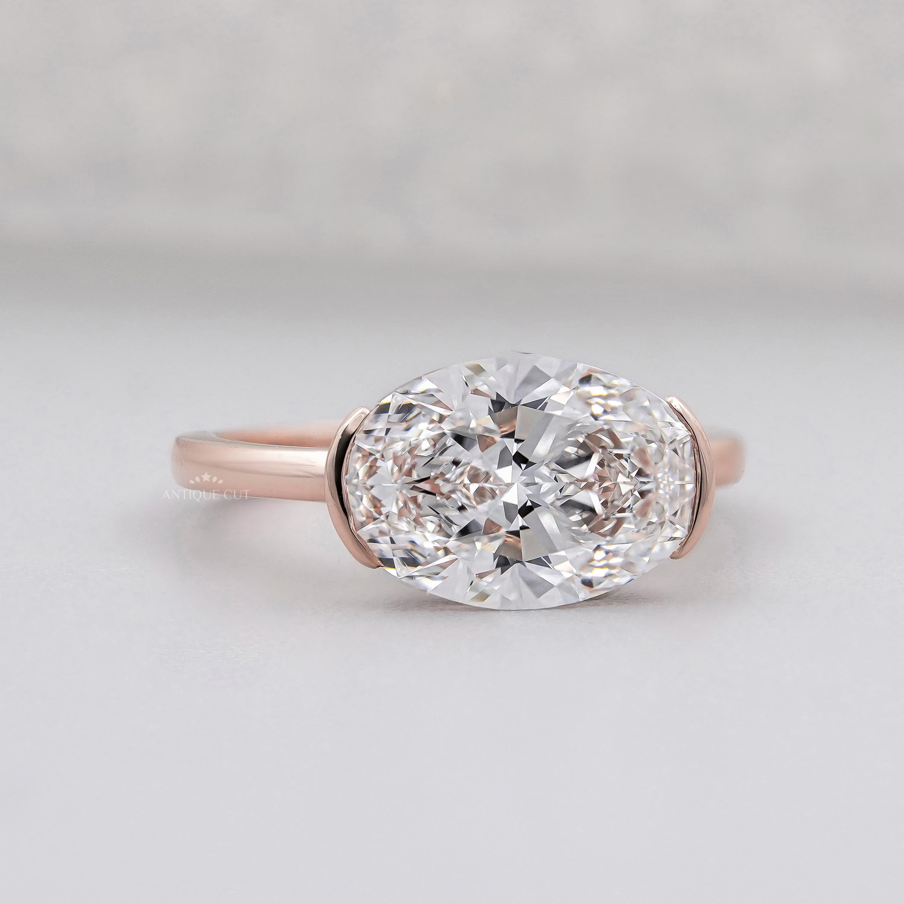 Rose gold ring with a large diamond on a light gray background