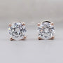 Pair of diamond stud earrings on a gray background