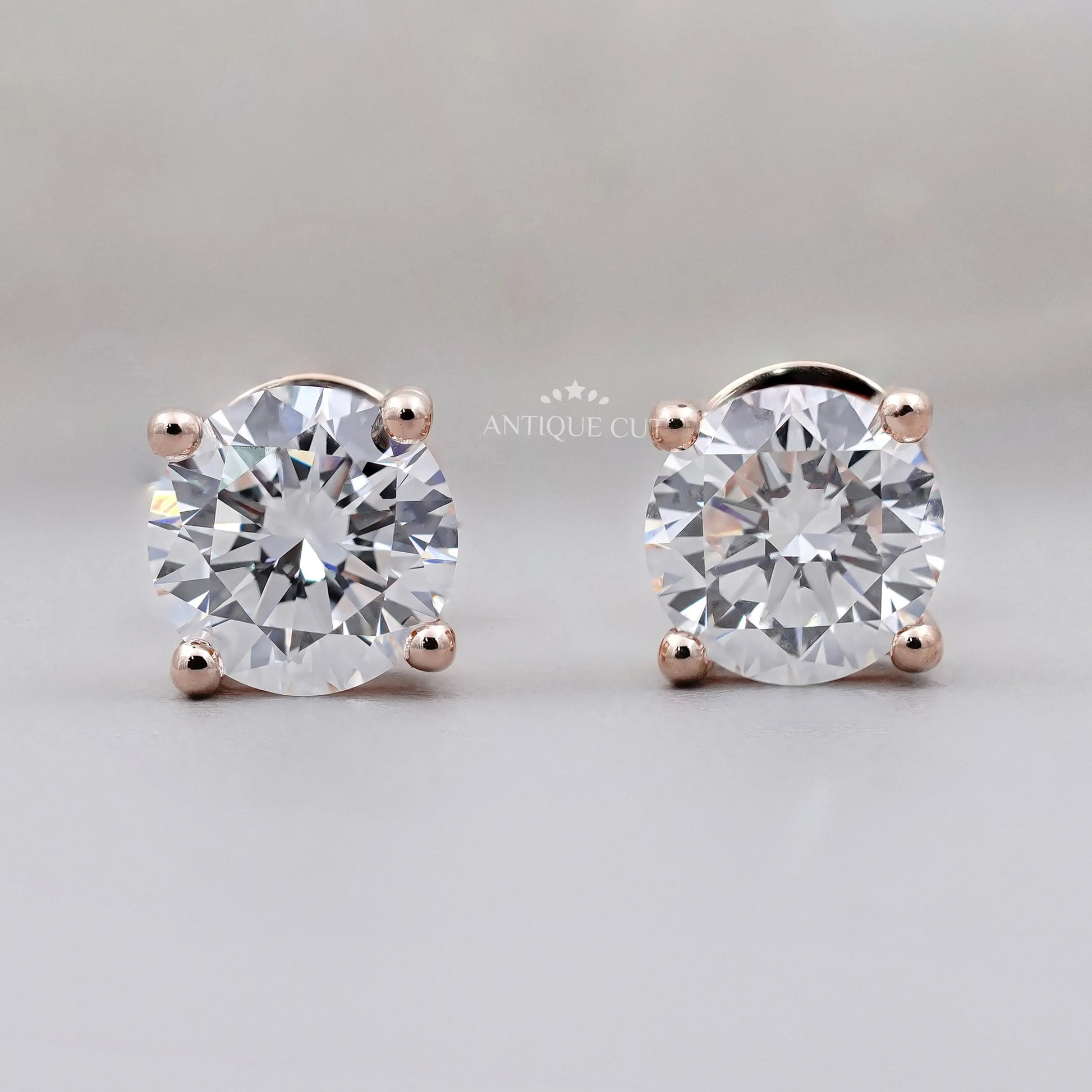 Pair of diamond stud earrings on a gray background