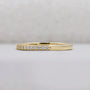 Gold ring with small diamonds on a light gray background