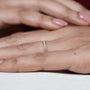 Gold ring with small diamonds on a person's finger