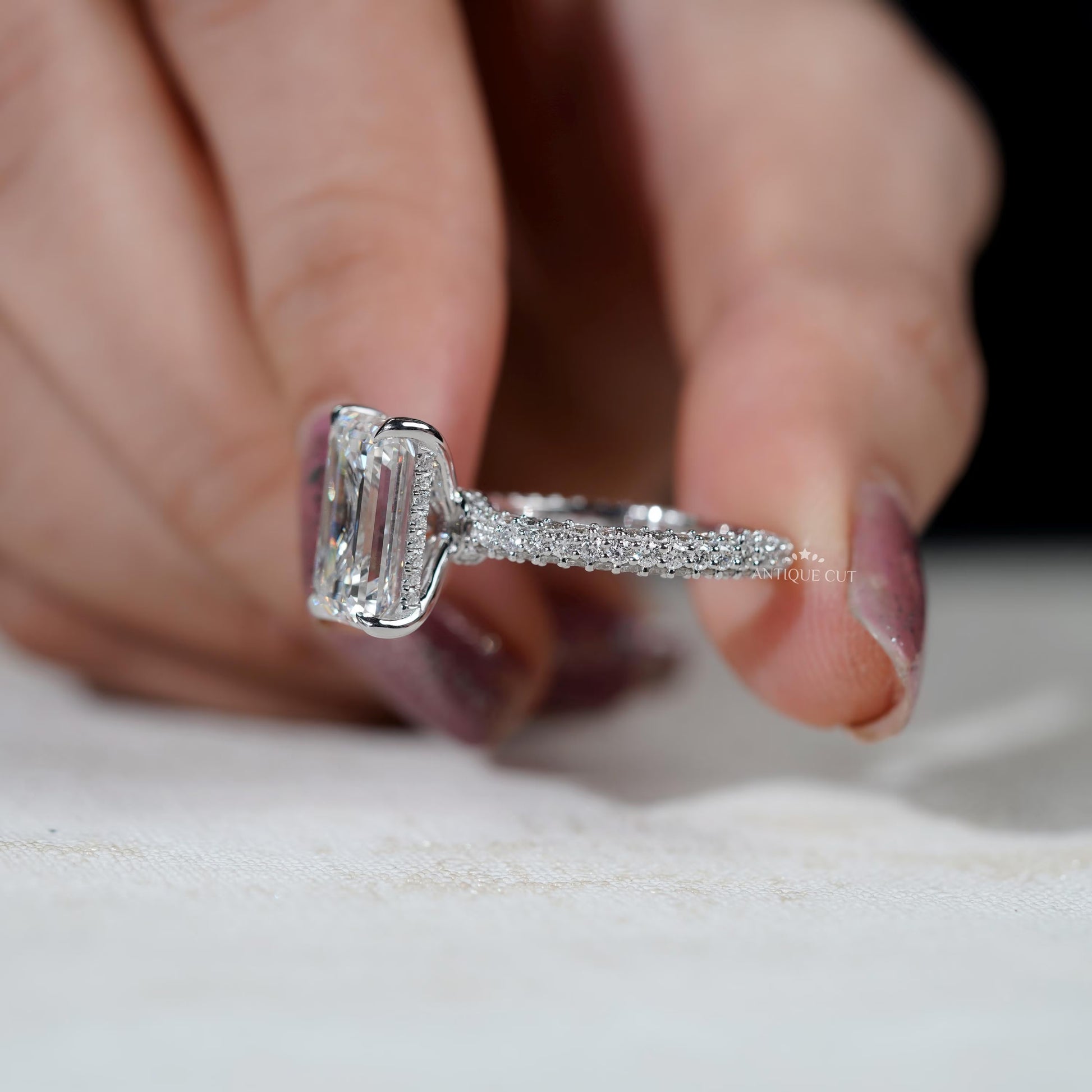 Hidden halo engagement ring with emerald cut center stone