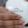 Brilliant emerald cut diamond ring with marquise and round side stones
