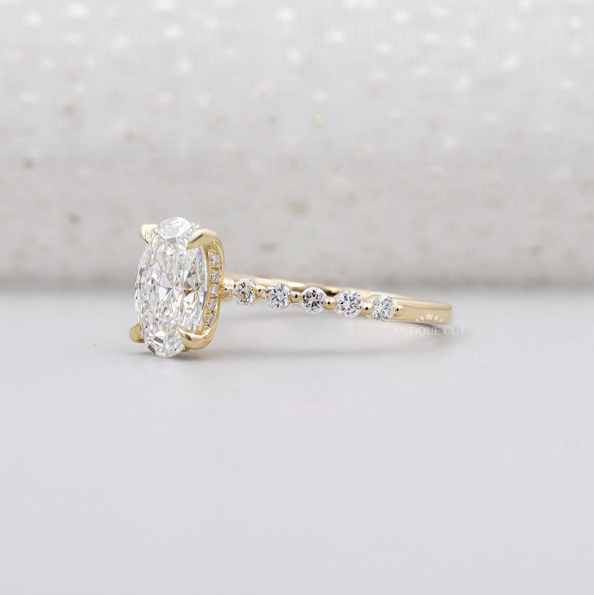 Yellow gold oval diamond ring with hidden halo and pave band