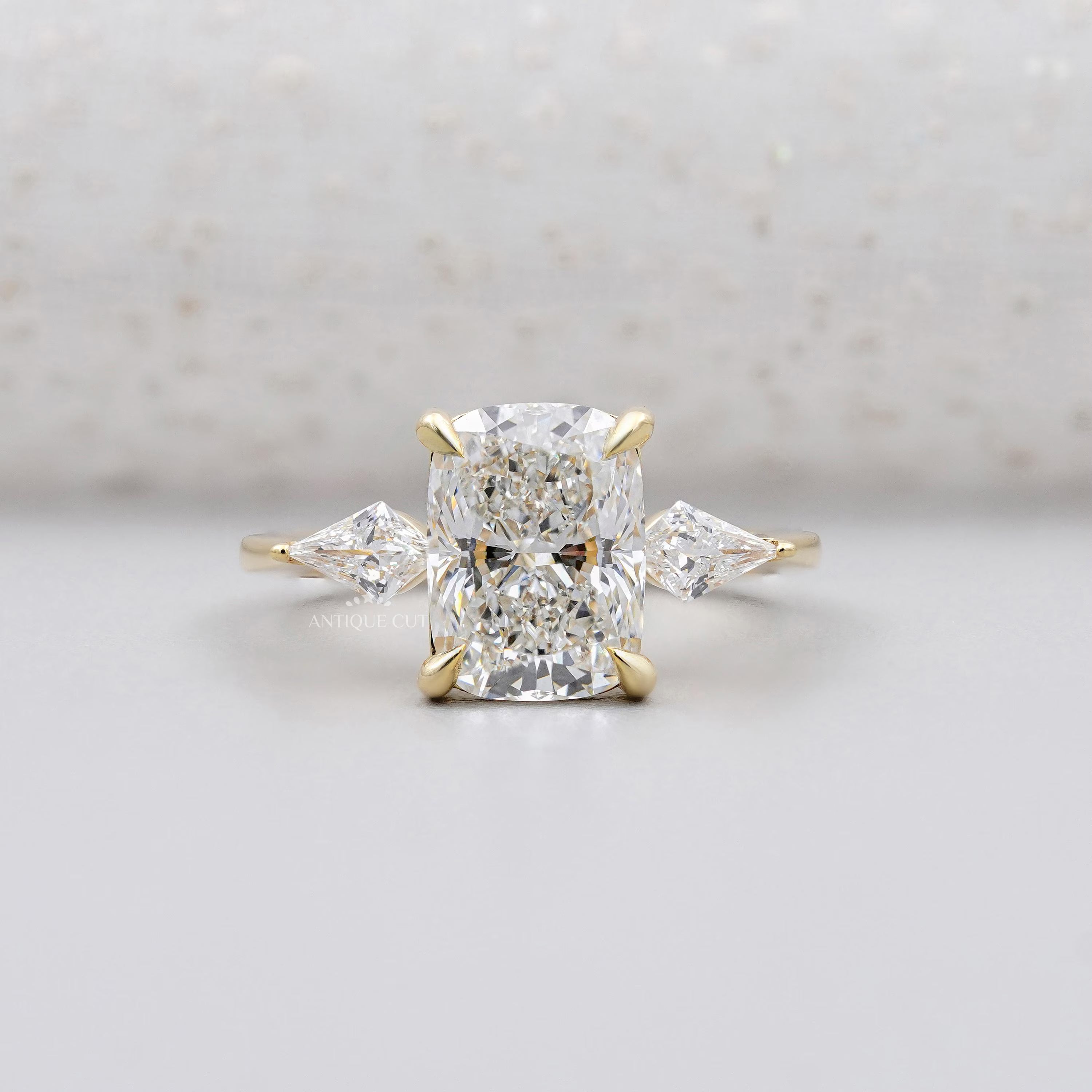 Yellow gold cushion cut diamond ring with kite side stones