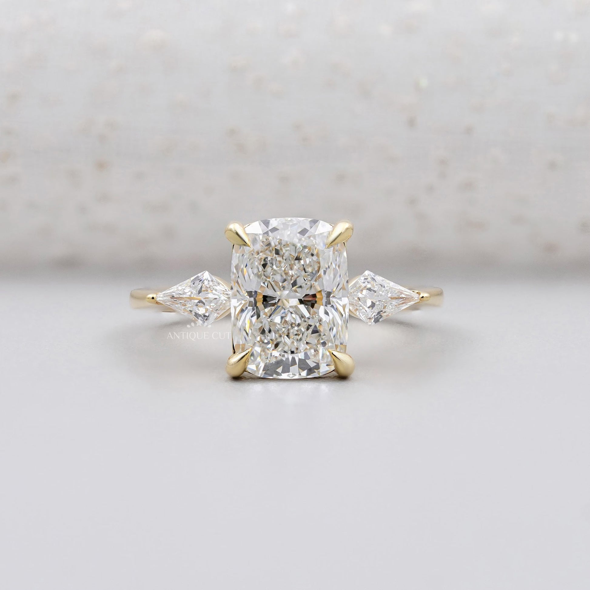 Yellow gold cushion cut diamond ring with kite side stones