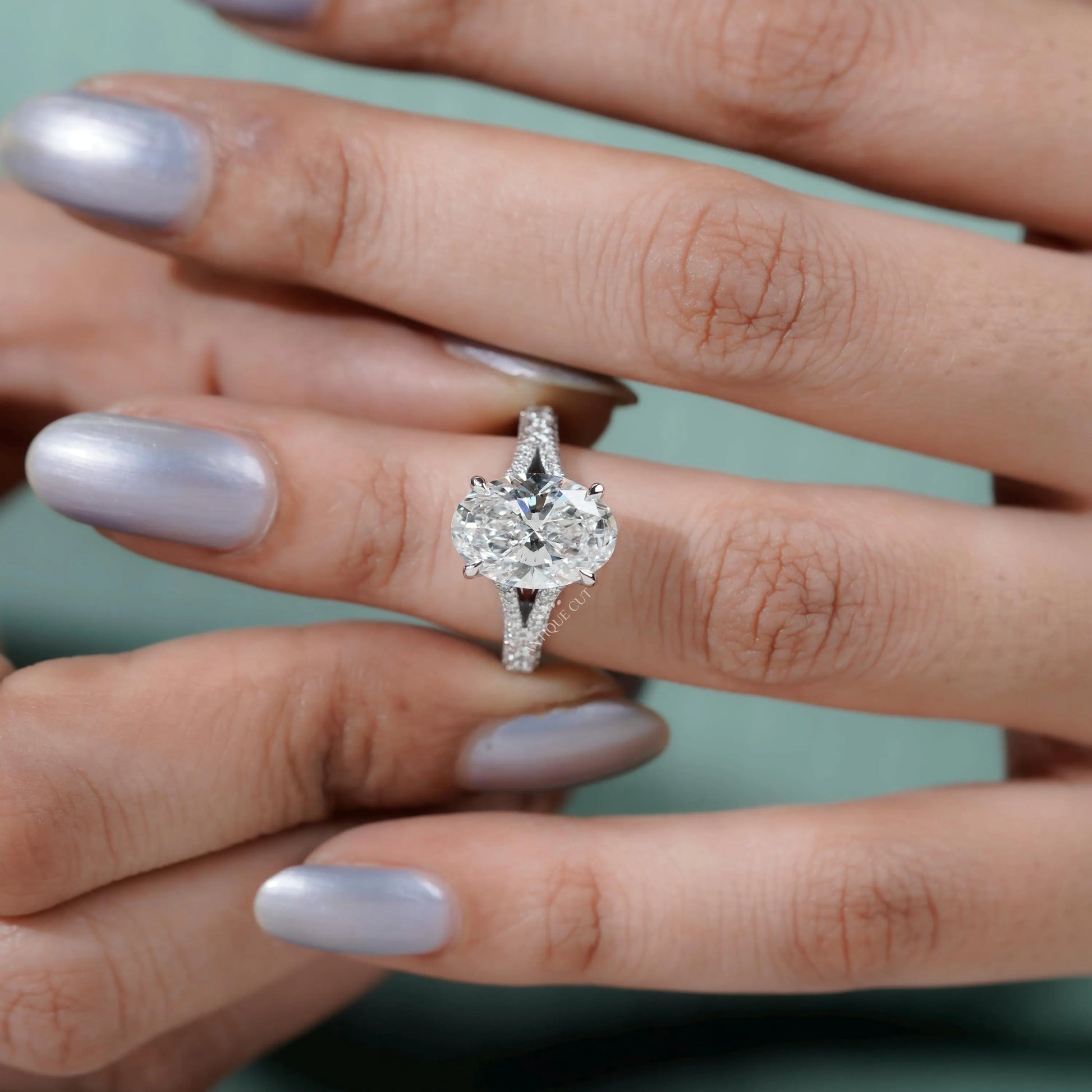 White gold ring featuring pave diamonds and oval cut