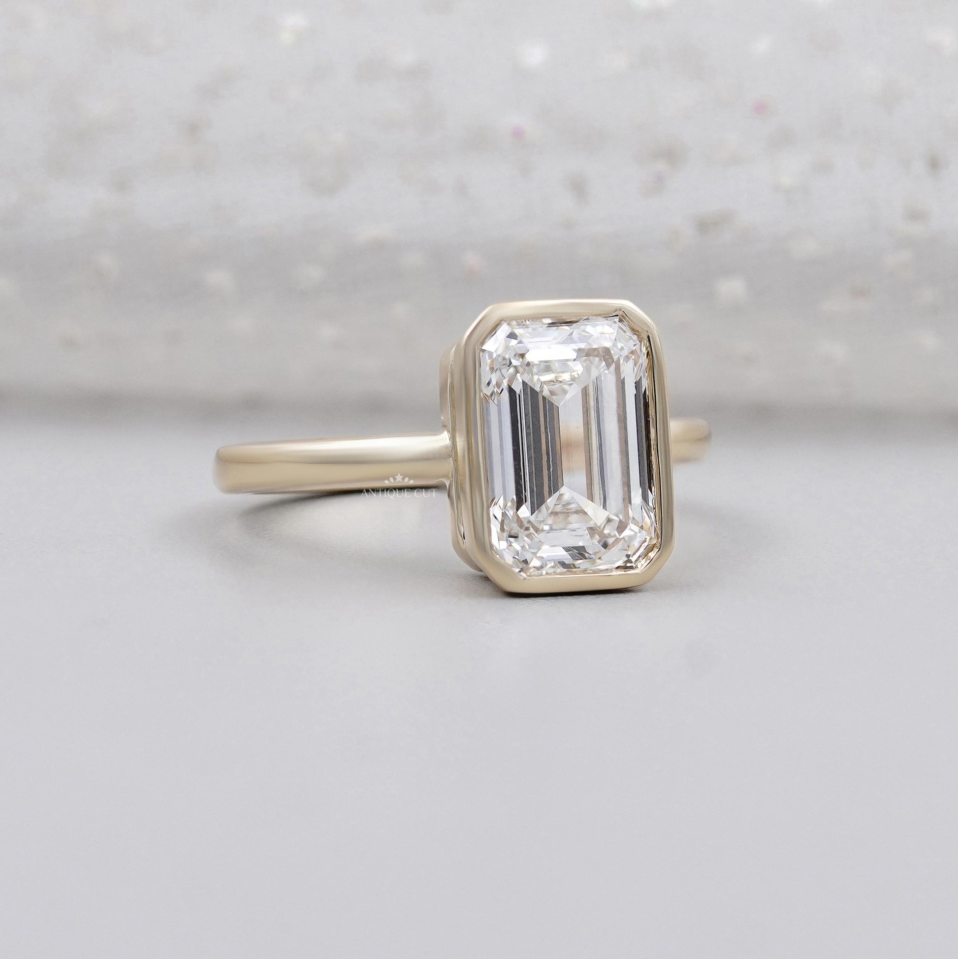 Emerald cut diamond bezel solitaire engagement ring in yellow gold