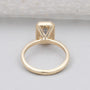 Emerald cut diamond ring with gold bezel setting close-up