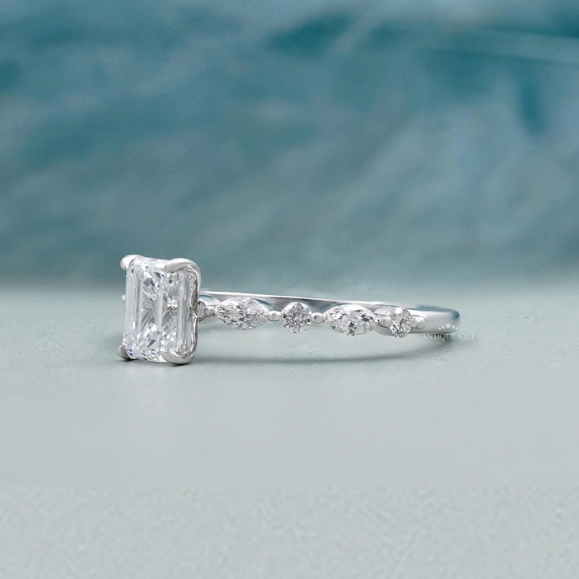 White gold emerald diamond engagement ring with pave diamonds