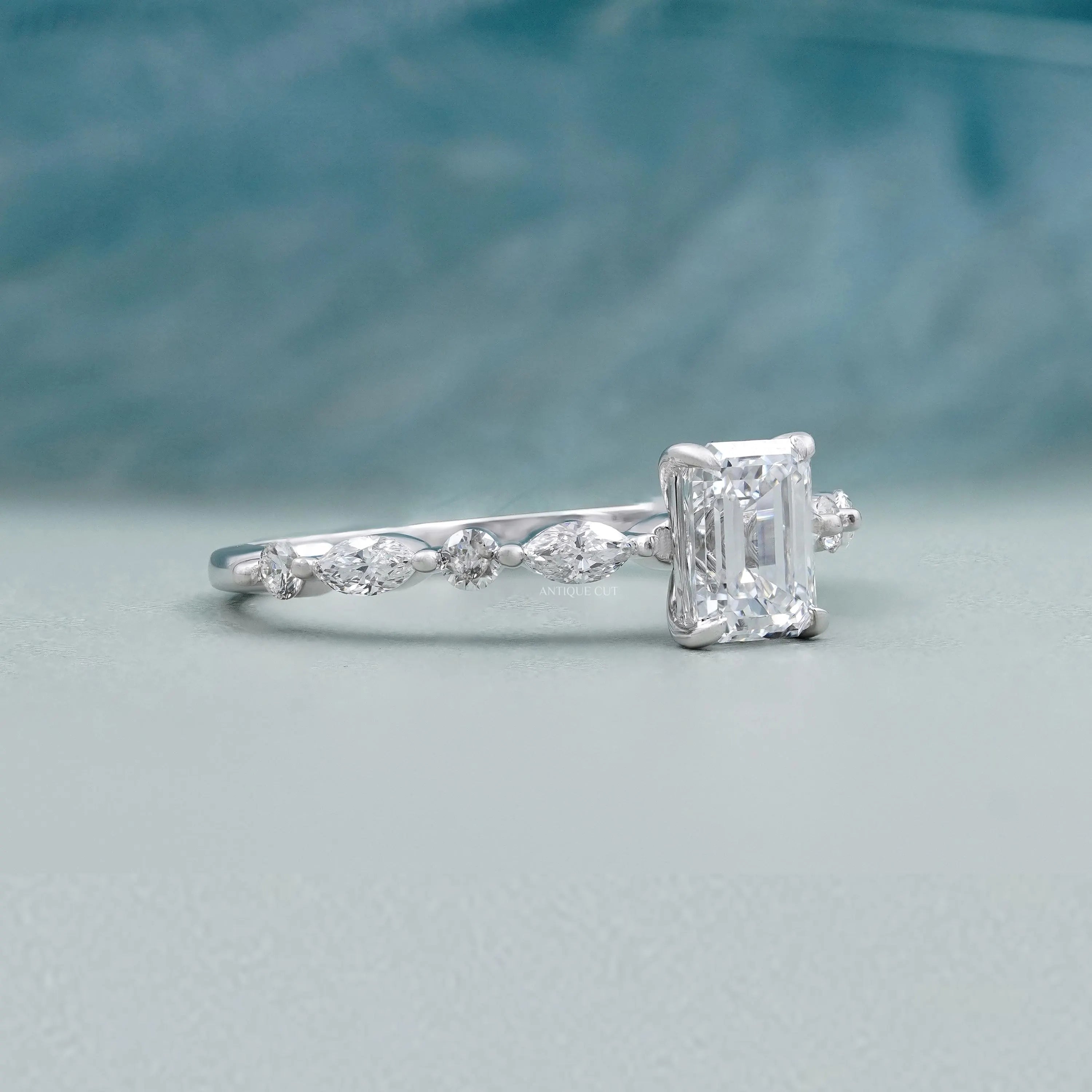 Emerald cut diamond engagement ring with pave band setting