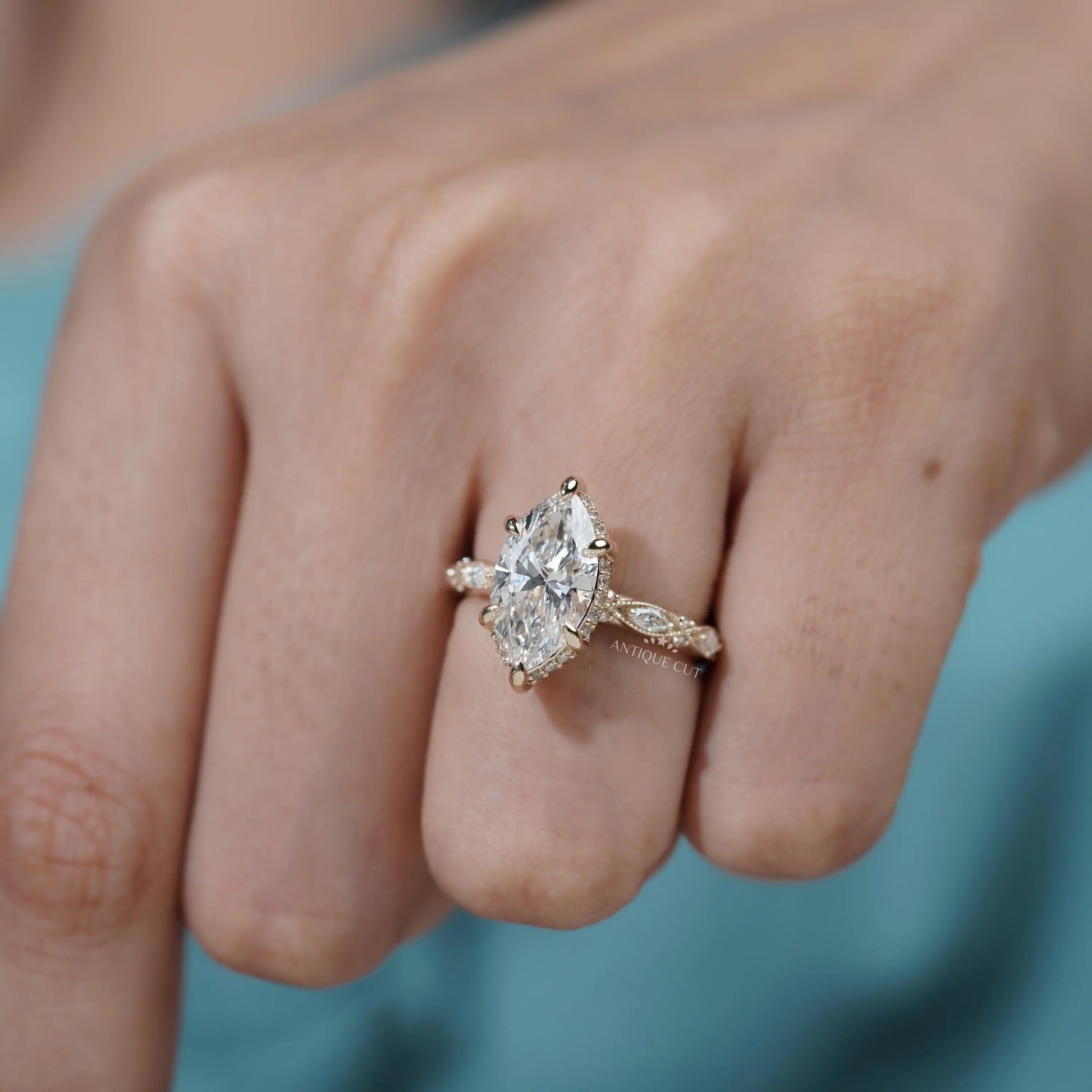 Marquise diamond proposal ring with intricate yellow gold band