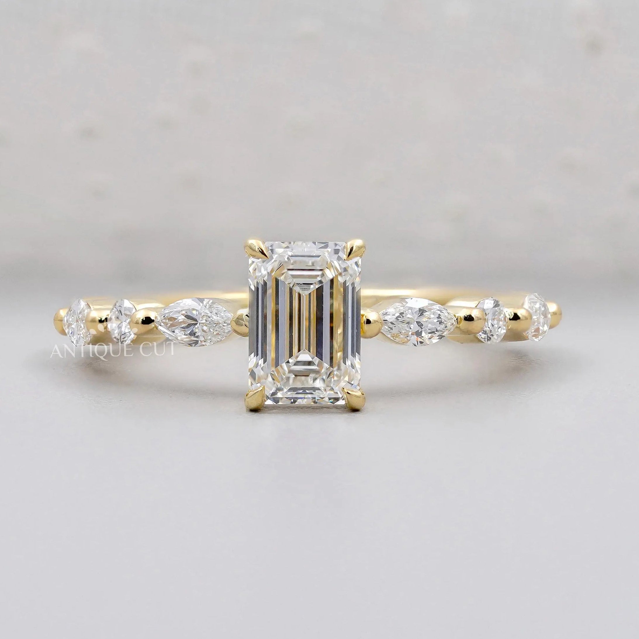 Emerald cut engagement ring in yellow gold with side stones