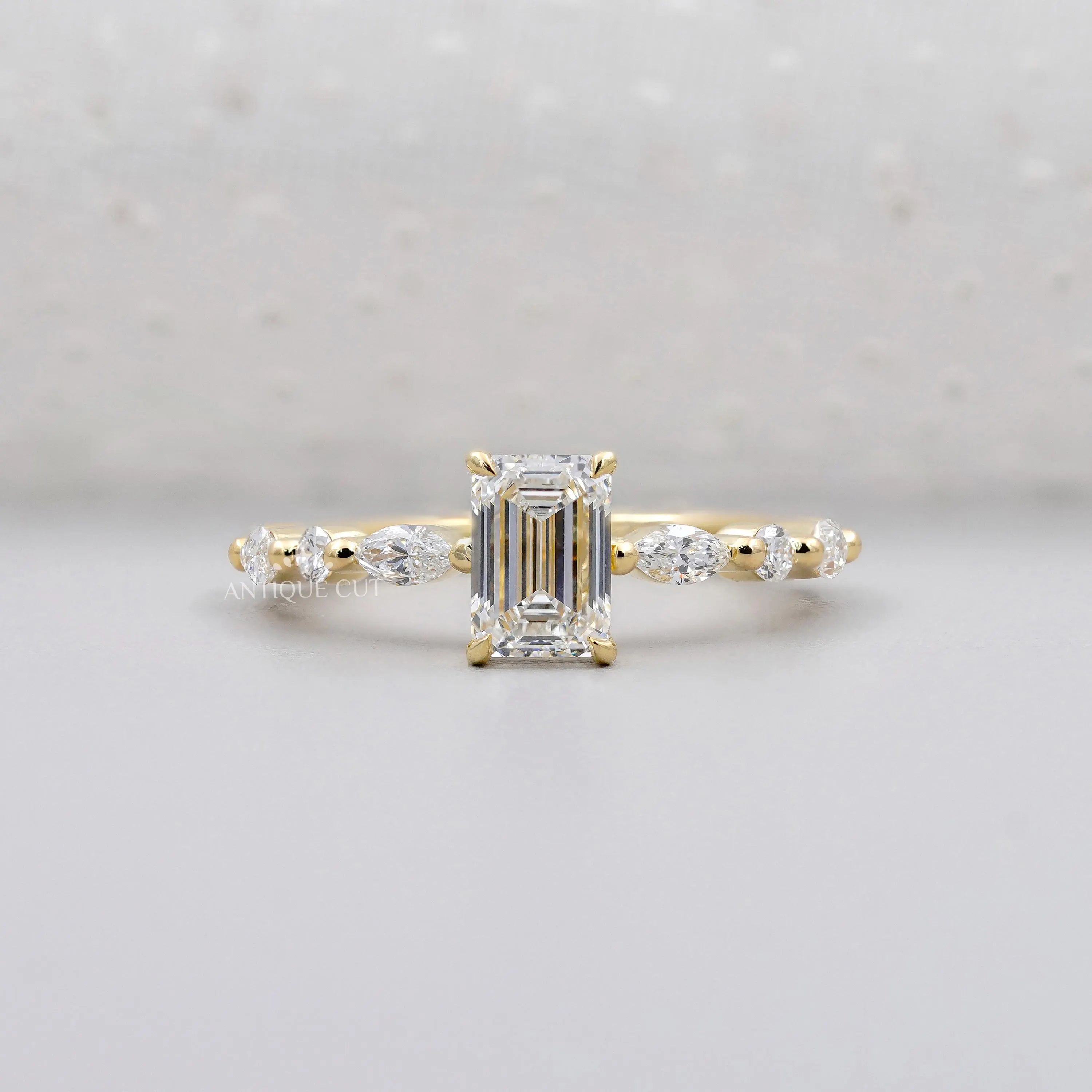 Emerald cut engagement ring in yellow gold with side stones