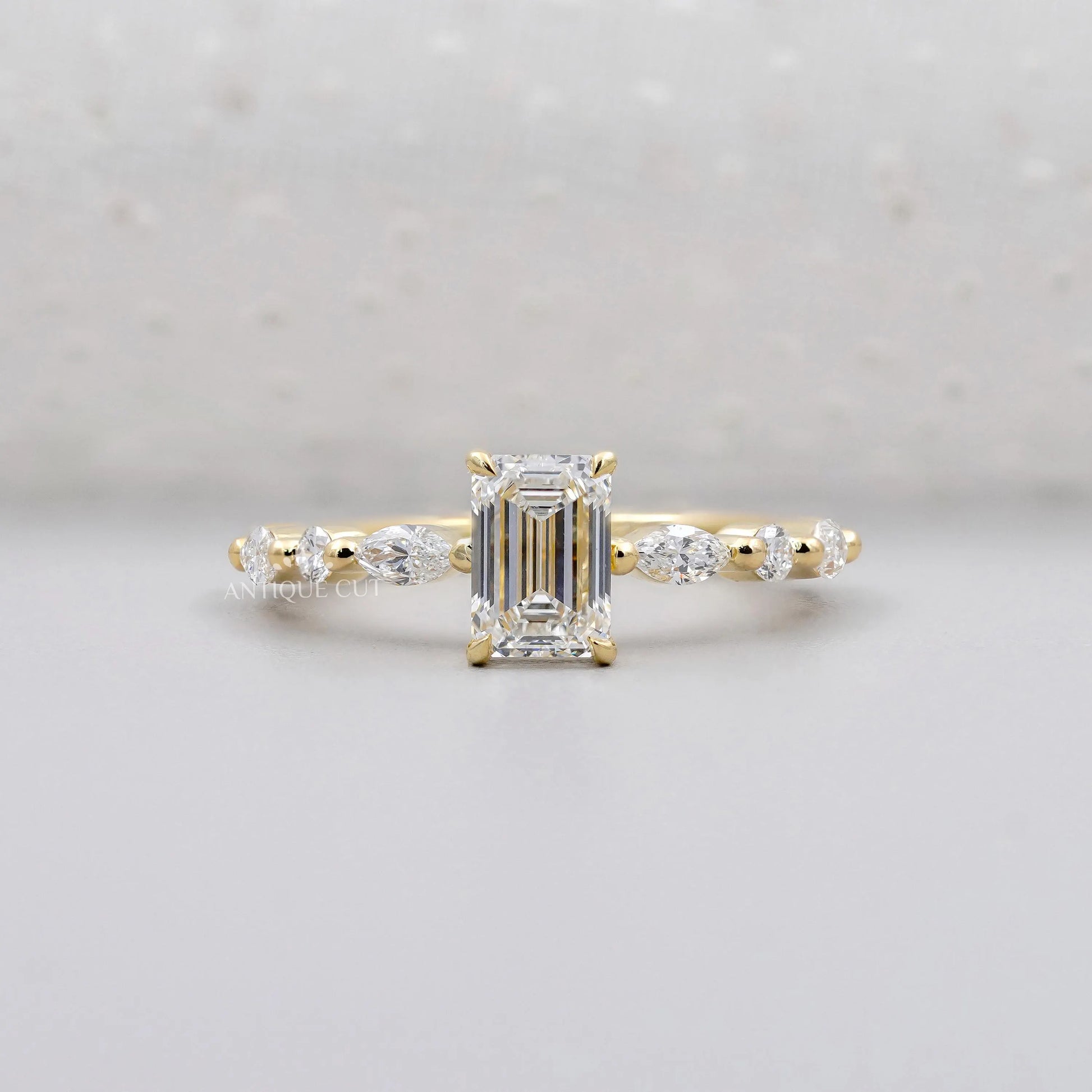 Emerald cut engagement ring in yellow gold with side stones