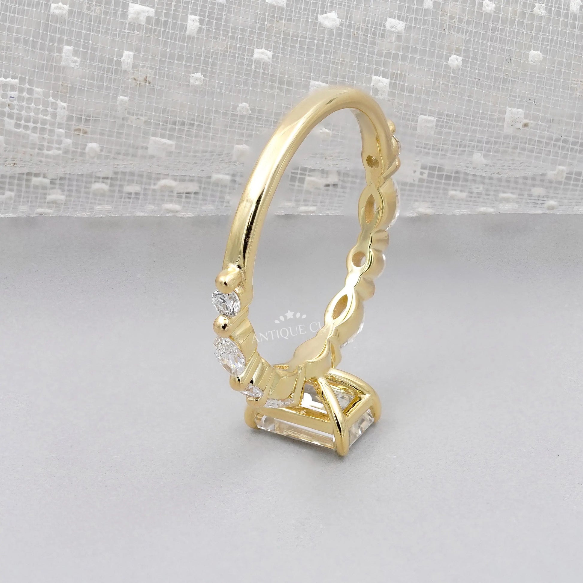 Emerald cut diamond engagement ring with round & marquise side stones